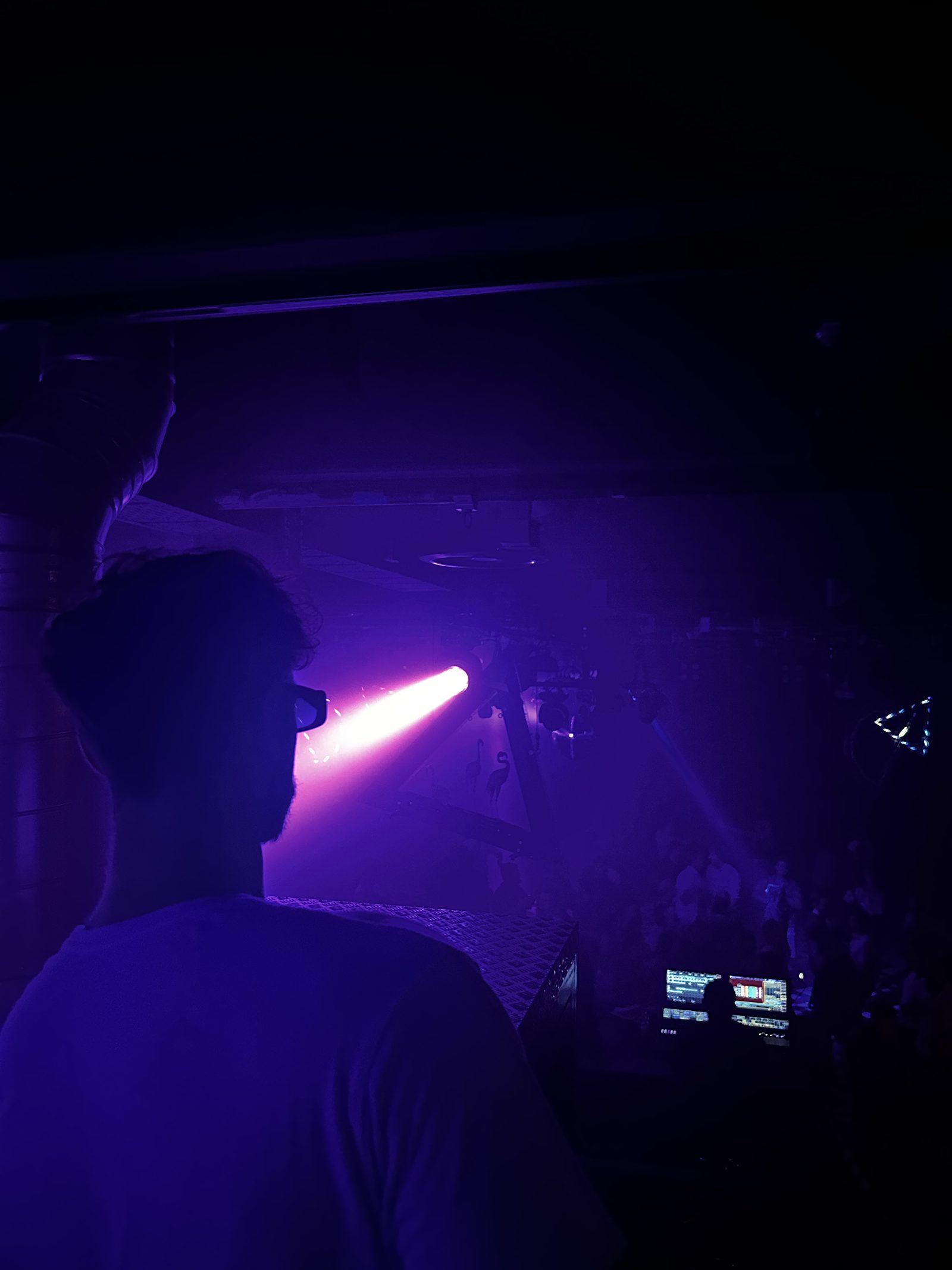 DJ behind the booth under a purple beam at a Nocstar night